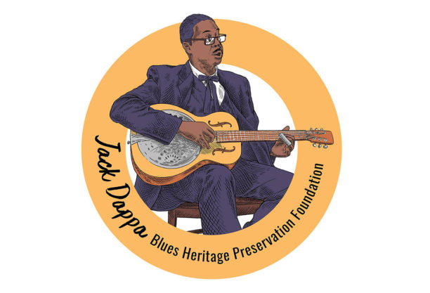 The logo for Jack Dappa Blues featuring an illustration of a Black man playing a guitar surrounded by an orange circle and the words "Jack Dappa Blues Heritage Preservation Foundation". 